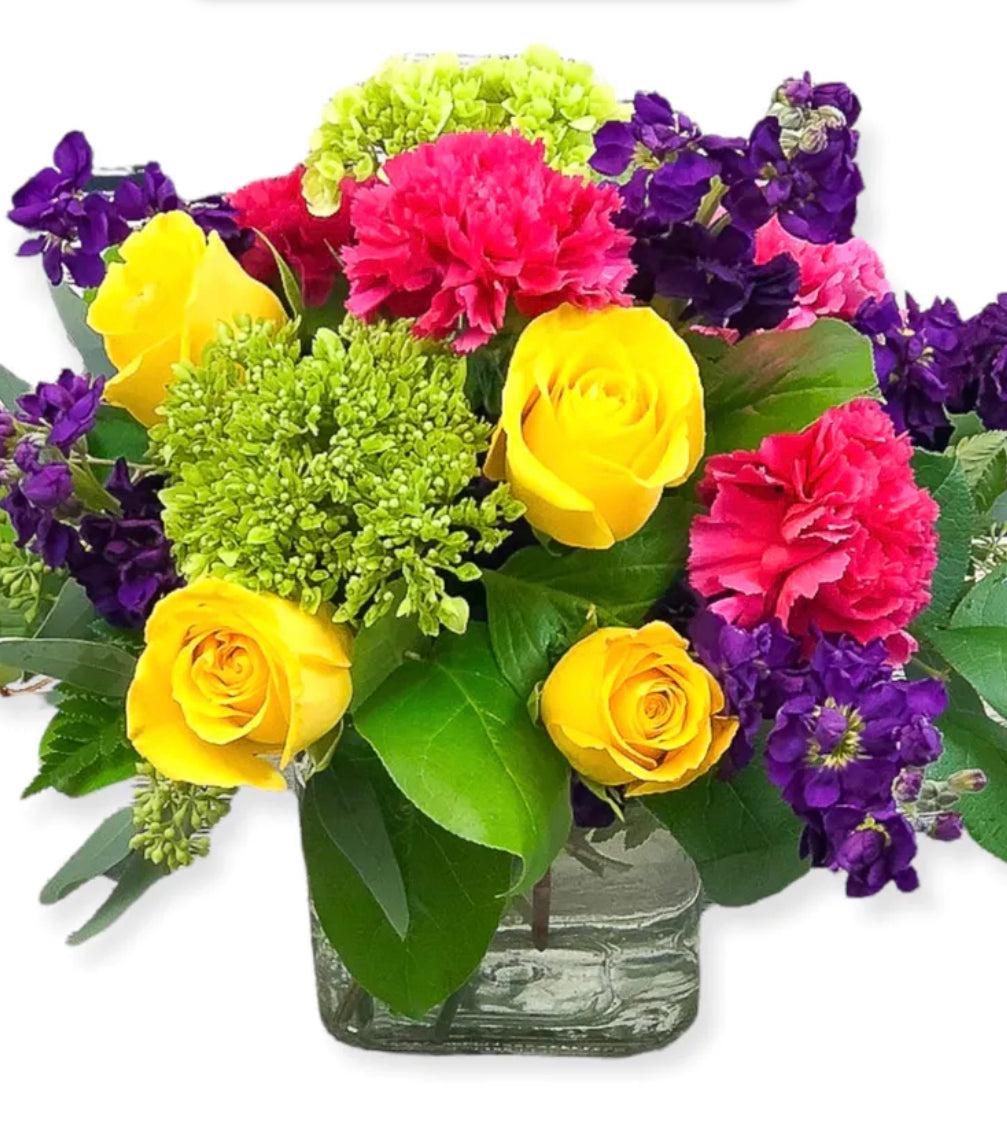 Bright mix explosion colors bouquet in small square vase